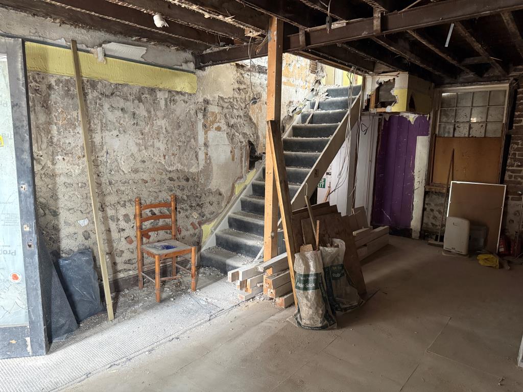 Lot: 52 - FREEHOLD SHOP AND UPPER PARTS IN NEED OF COMPLETE REFURBISHMENT - View of retail unit and staircase from front